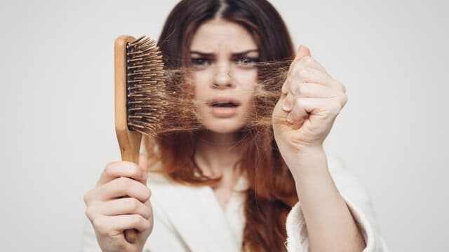 a young lady shocked with hair loss in women
