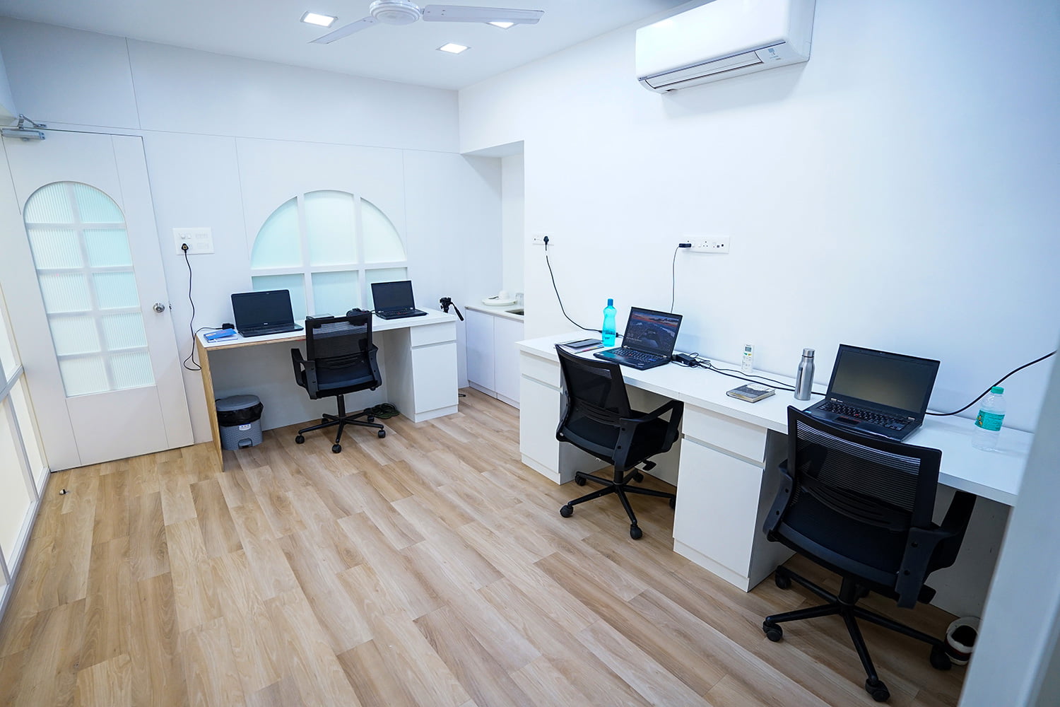 an ac room with tables and chairs with laptops on the table