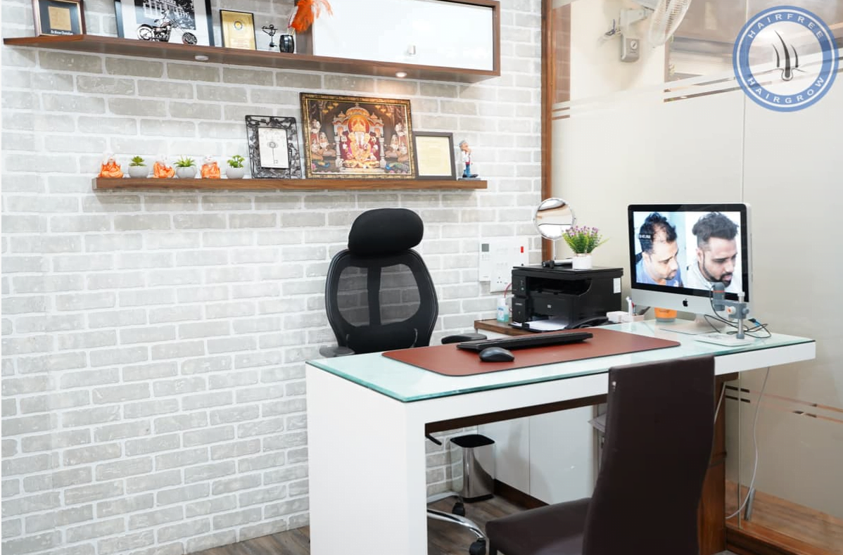 doctor's consultation cabin with monitor showing before and after of hair transplant results at surat branch of hair free and hair grow